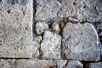 A Gray brick surface texture that is worn and old