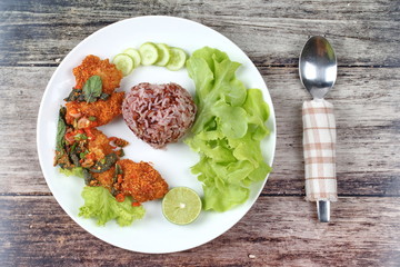 Organic red jasmine rice  with spicy sour fried chicken salad .