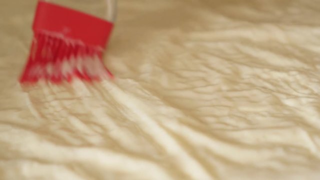 Vegetable oil and eggs mixture spreading over phyllo thin sheets of dough 4K 2160p 30fps UHD footage - Homemade filo pie with cheese and spinach 3840X2160 UltraHD video