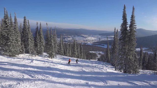 Woman skier goes down to winter ski track from mountain's top