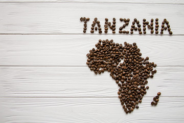 Map of the Tanzania made of roasted coffee beans layin on white wooden textured background