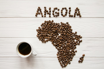 Map of the Africa made of roasted coffee beans and cup of coffee on white wooden textured...