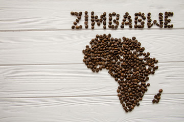 Map of the Africa made of roasted coffee beans  on white wooden textured background with space for text