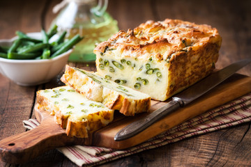 Homemade rustic potato loaf with green beans sliced on wooden cutting board