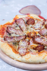 Flat lay overview of pizza with domestic ham sirloin and sausage