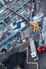 Workers fitting high heavy crane using mobile truck lift in Lond