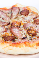 Flat lay overview of pizza with domestic ham sirloin and sausage