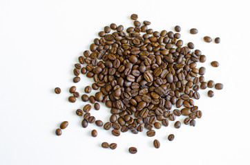 Grains of black coffee spilled on a white background