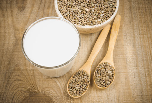 Hemp milk, seeds on wooden background . Close Up .