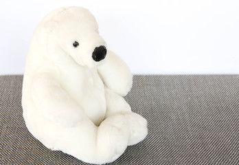 polar bear doll sitting on gray floor