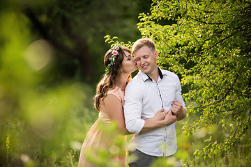 Obraz premium Couple in love hugging in spring garden and smiling. Love concept