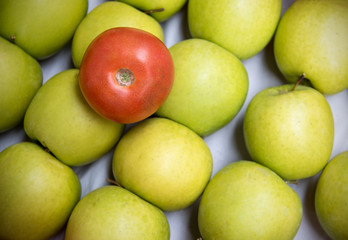 Red tomato on green apples