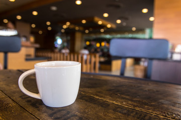 White coffee cup on the table inside coffee shop