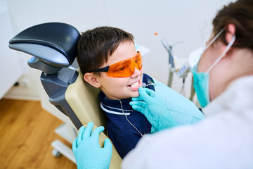 Boy child in orange glasses have a dentist.