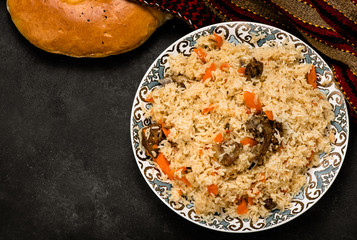 Pilaf on plate with oriental ornament and Traditional Asian breads - churek. Plov. Top view.