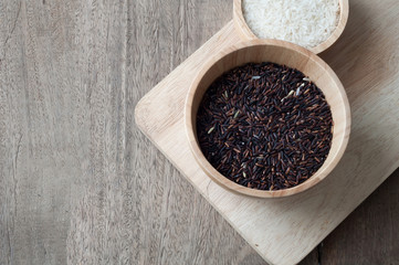 black grain of rice on wood table.