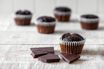 Chocolate muffins on a white rustic wooden table - selective focus, copy space