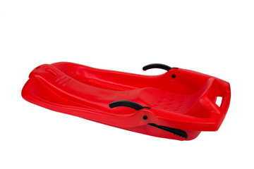 Plastic red sled for skiing on white background