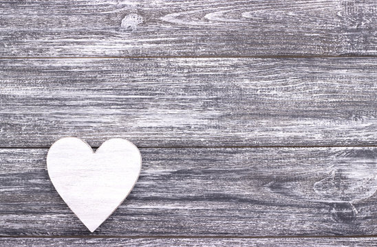 Decorative white heart on gray wooden background with copy space.