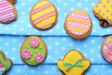 Fototapeta na wymiar Delicious Easter cookies on blue dotted napkin, closeup