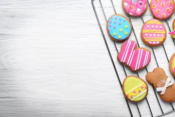 Foto auf Acrylglas Decorative gingerbread Easter cookies on baking wire rack and white wooden background © Africa Studio