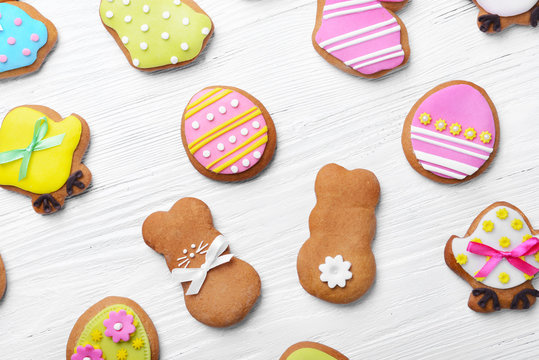 Decorative gingerbread Easter cookies on white wooden background