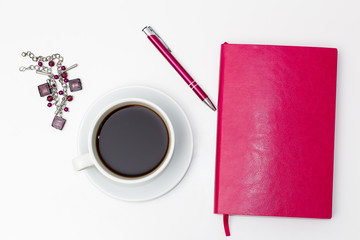 Obraz na płótnie Canvas pink diary with pen, Cup of black coffee and the decoration into the hands on white background on white background. business minimal concept for women. Flat lay, top view.