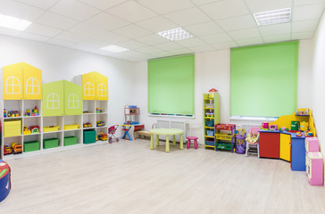 Bright Interior of a modern kindergarten in yellow and green colors. Panoramic view.