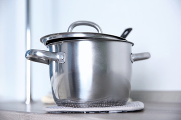 Stainless saucepan on grey kitchen table, closeup
