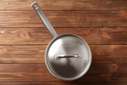 Stainless saucepan on wooden table