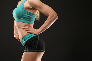 Fototapeta premium Young athletic woman on black background, closeup