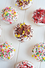Cupcakes with white cream  and sprinkles on white background
