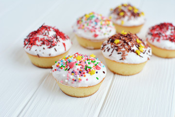 Cupcakes with white cream  and sprinkles on white background