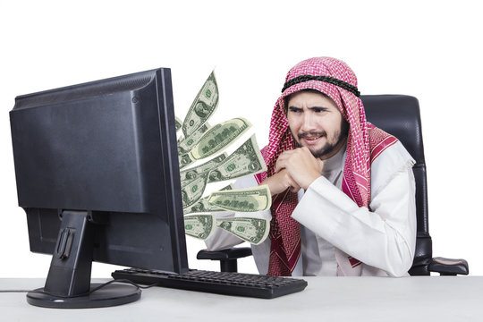 Arabian businessman with money on his computer