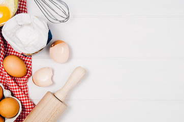 Baking a cake or pizza ingredients background. Top view photograph with kitchen utensils on vintage, natural, white, wooden background.