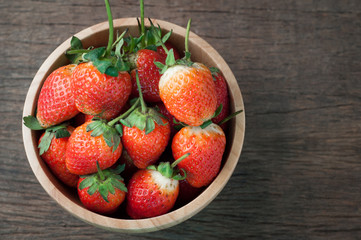 kitchen table with strawberry on wood plate.