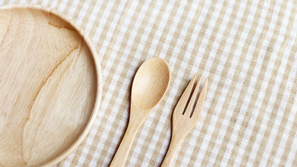 Wooden Plate, Fork and Spoon on table 