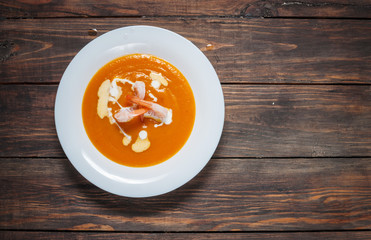 Pumpkin soup with shrimp on a wood