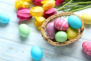 Easter eggs with tulips on a blue wooden table