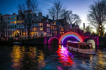 Rolgordijnen AMSTERDAM, NEDERLAND - 10 JANUARI 2017: Cruiseboten haasten zich in nachtgrachten. Lichtinstallaties op nachtgrachten van Amsterdam binnen Light Festival. 10 januari 2017 in Amsterdam - Nederland. © Unique Vision
