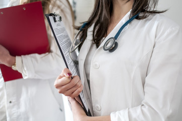 dottoressa con camice bianco, stetoscopio e cartella paziente