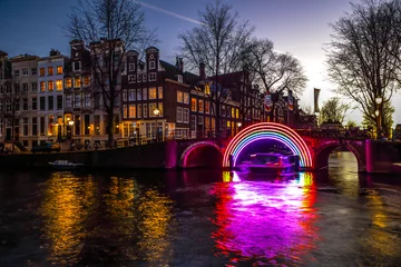 Zelfklevend Fotobehang AMSTERDAM, NETHERLANDS - JANUARY 10, 2017: Cruise boats rush in night canals. Light installations on night canals of Amsterdam within Light Festival. January 10, 2017 in Amsterdam - Netherland. © Unique Vision