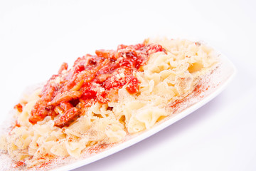 Tagliatelle mosse with tomato sauce with ham, sprinkled with parmesan
