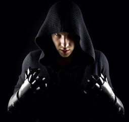 Emotional, young and attractive assassin in gloves on the black - 133410242
