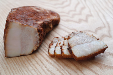Delicious smoked pork ham with spices. Cut in slices on a wooden