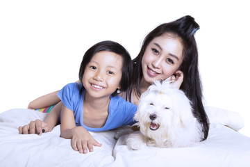 Mother and daughter with puppy on studio