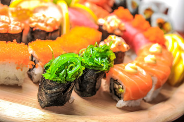 Nigiri sushi and sushi rolls with fish served on wooden table