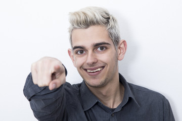 teen male smiling and pointing with your finger on white background