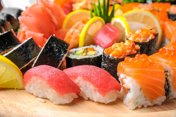 Nigiri sushi and sushi rolls with fish served on wooden table