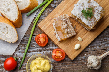 Homemade jelly meat with mustard, bread, tomatoes and garlic on the table. Holodets